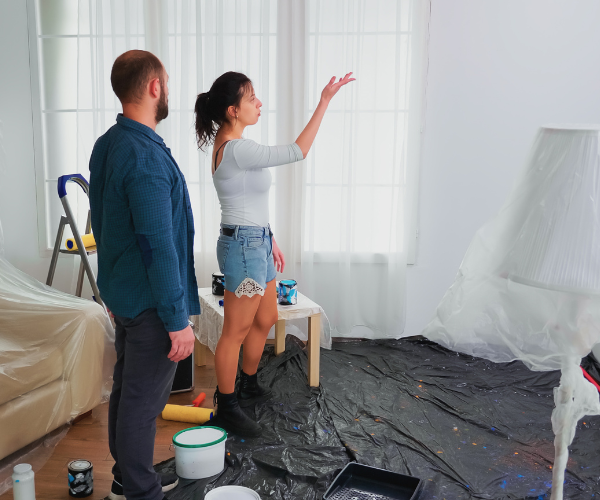 Homeowners discussing painting work while preparing room