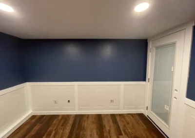 Room with dark accent wall and wood flooring