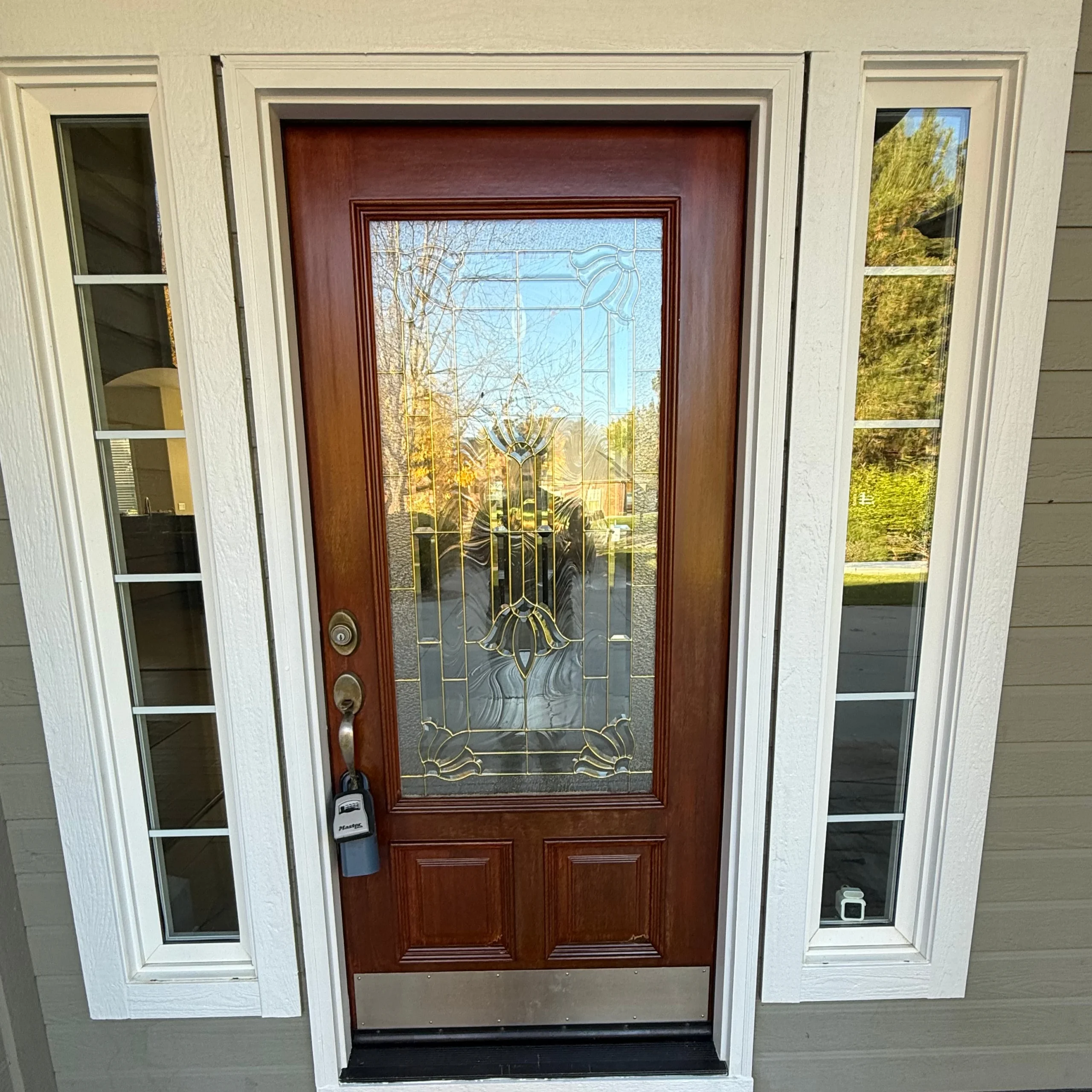 Wood front door with stained finish and glass panel
